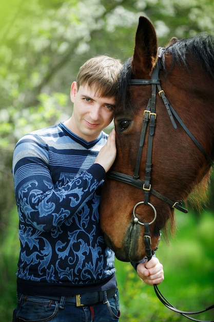 Portrait de l'homme près d'un cheval brun