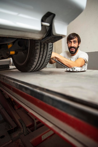 Portrait d'un homme réparant une voiture dans une usine