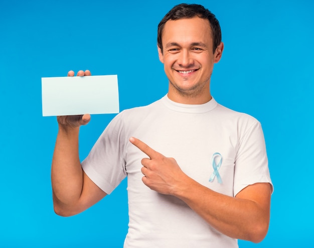 Portrait d'un homme avec un ruban bleu et un panneau blanc.