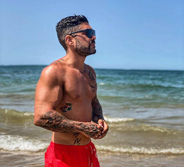 Portrait d'un homme sans chemise debout sur la plage
