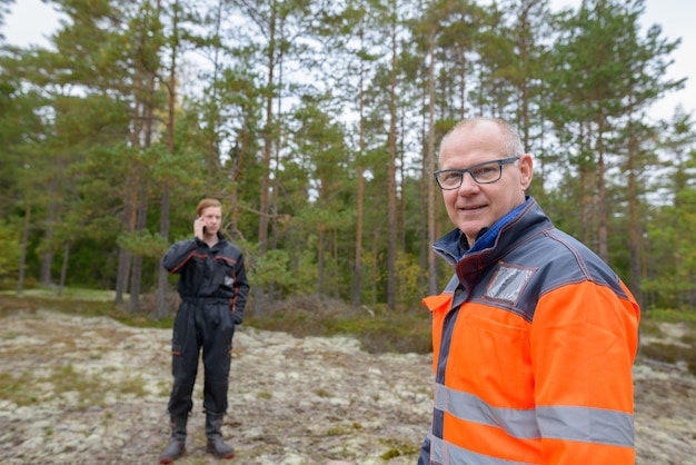 Portrait d'homme scandinave mature et jeune homme scandinave prêt pour la récolte dans la forêt ensemble à l'extérieur