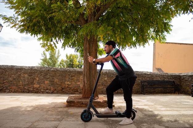 Portrait d'un homme avec un scooter électrique et mobile