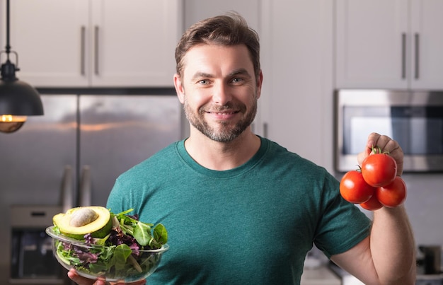 Portrait d'un homme séduisant préparant un repas de perte de poids naturel frais à la maison de cuisine à l'intérieur beau