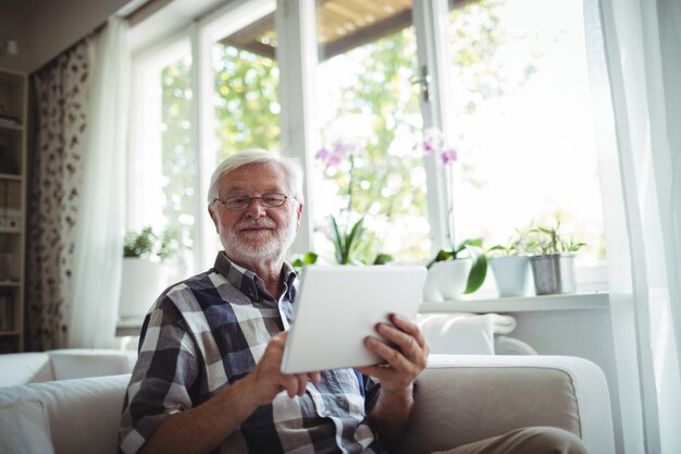 Portrait d'un homme senior à l'aide d'une tablette numérique