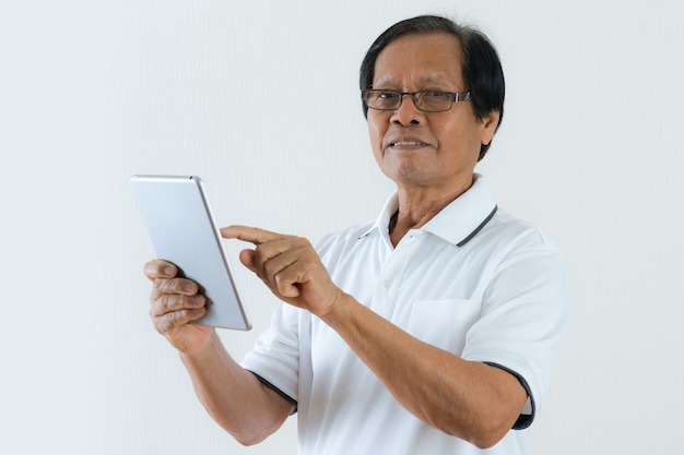 Portrait d'un homme senior asiatique à l'aide de tablette