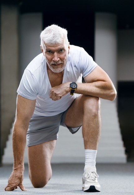 Portrait d'un homme senior aux cheveux gris beau en t-shirt blanc Concept de sport et de santé