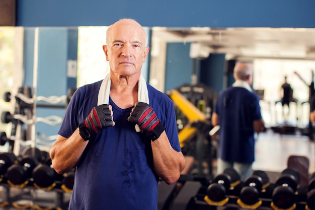 Un portrait d'homme senior chauve dans la salle de sport en regardant la caméra. Concept de personnes, de santé et de mode de vie