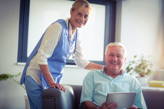 Portrait d'un homme senior et d'une femme médecin à l'aide d'une tablette numérique