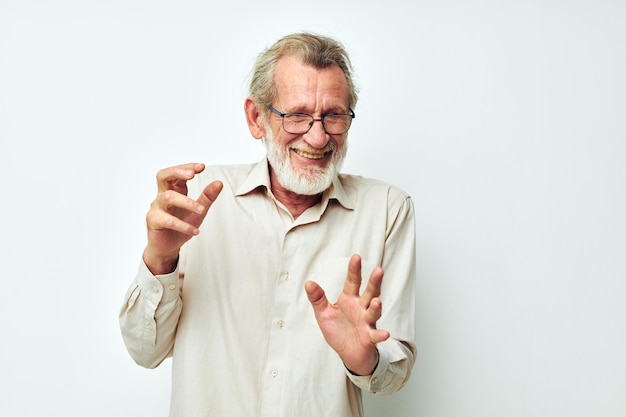 Portrait d'un homme senior heureux avec une barbe grise dans une chemise et des lunettes fond isolé