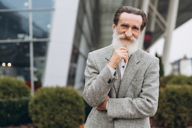 Portrait d'un homme senior heureux sur les immeubles de bureaux avec espace de copie