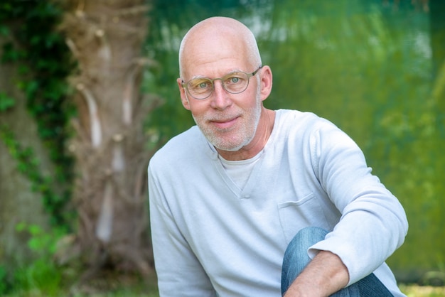 Portrait d'un homme senior avec des lunettes, à l'extérieur