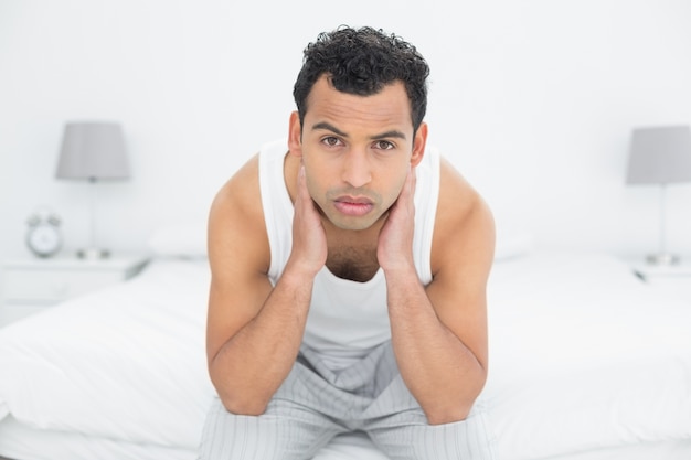 Portrait d&#39;un homme sérieux assis sur le lit