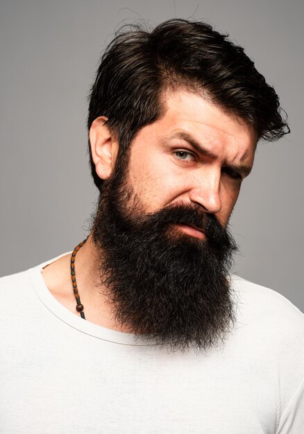 Portrait d'un homme sérieux confiant a la barbe et la moustache semble sérieusement isolé des modèles de gars hipster dans le studio homme d'affaires pensant avec l'expression regardant le visage de modèle masculin beau en gros plan