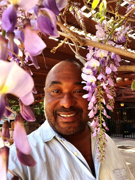 Photo portrait d'un homme soufflant des fleurs