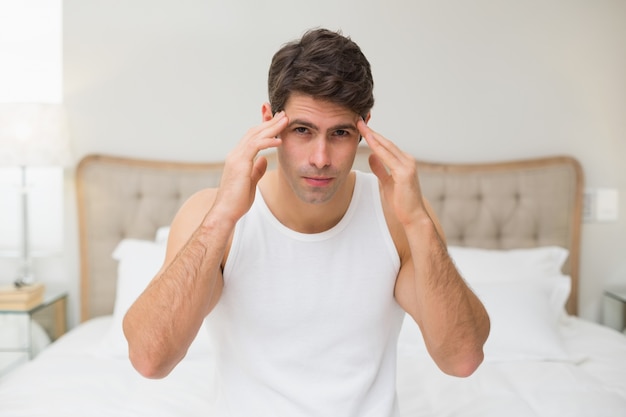 Portrait d&#39;un homme souffrant de maux de tête au lit