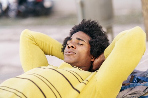 Photo portrait d'un homme souriant allongé sur un extérieur jaune