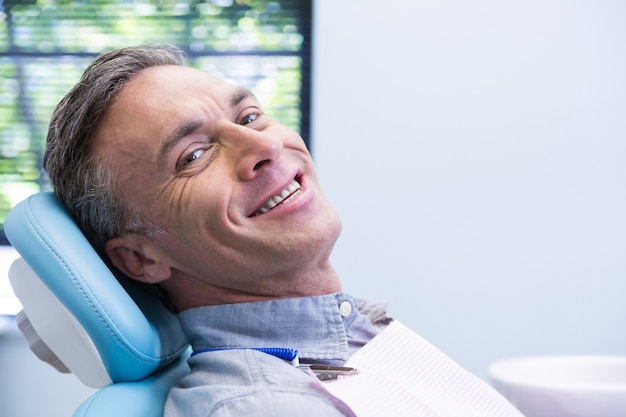 Portrait d'homme souriant assis sur une chaise