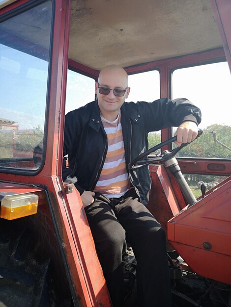 Photo portrait d'un homme souriant assis dans un tracteur