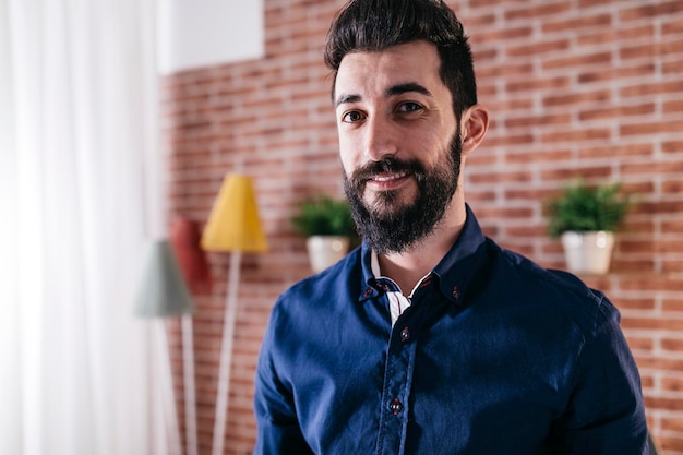 Portrait d'un homme souriant debout à la maison