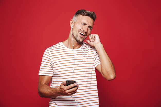 Portrait d'un homme souriant debout sur le rouge