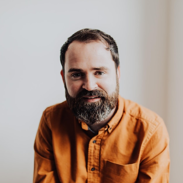 Portrait d'un homme souriant sur un fond blanc