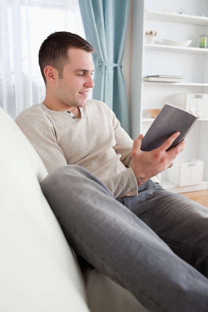 Portrait d&#39;un homme souriant, lisant un livre