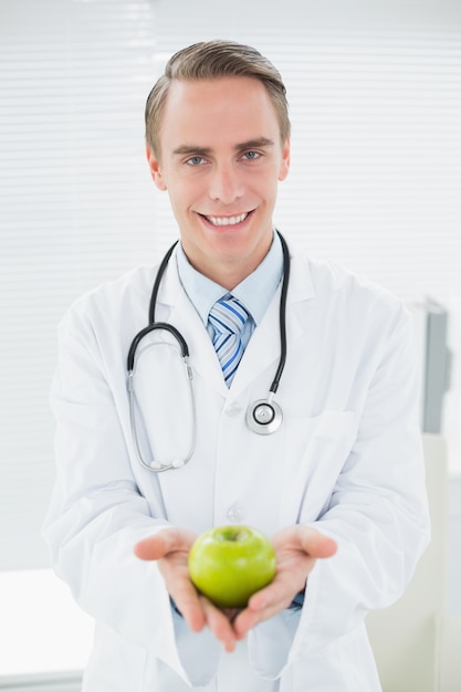 Portrait d&#39;un homme souriant avec une pomme verte