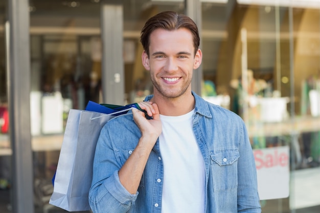 Portrait d&#39;un homme souriant avec des sacs à provisions