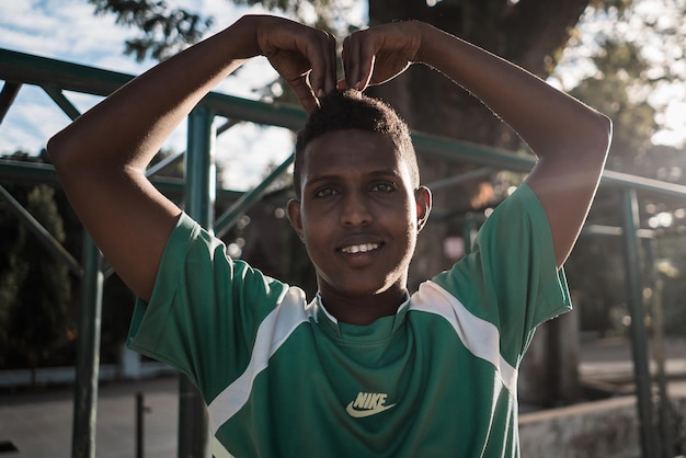 Portrait d'un homme souriant touchant la tête à l'extérieur