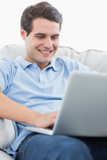 Portrait d&#39;un homme souriant en utilisant son ordinateur portable
