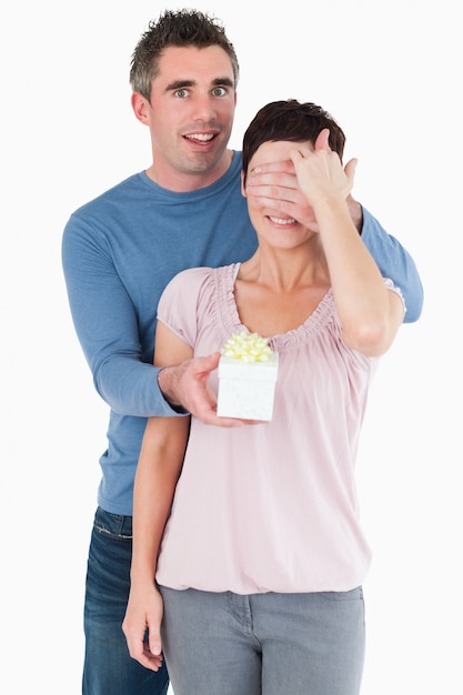 Portrait d&#39;un homme surprenant sa femme avec un cadeau