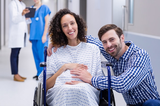 Portrait d'un homme touchant le ventre de femme enceinte dans le couloir