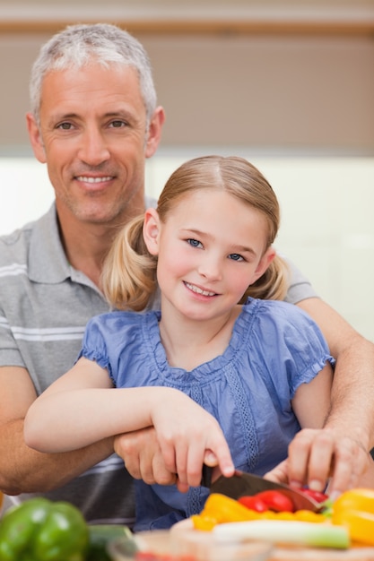 Portrait d&#39;un homme tranchant du poivre avec sa fille