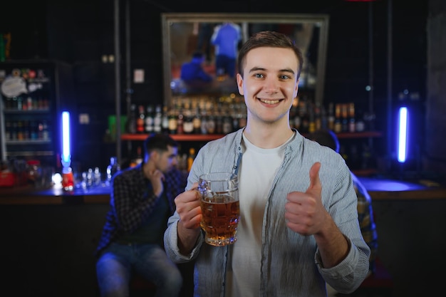 Portrait d'hommes gais buvant de la bière au bar