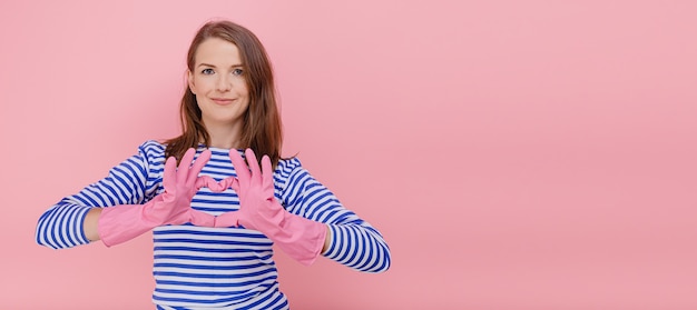 portrait horizontal femme faisant un geste cardiaque sur la poitrine dans des gants en caoutchouc