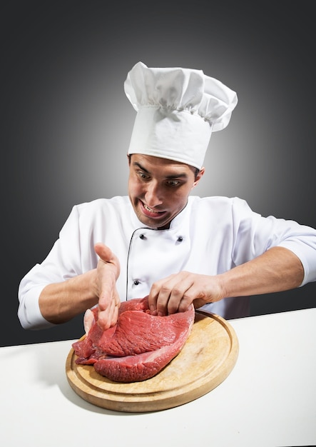 Portrait humoristique d'un homme en toque avec un morceau de viande