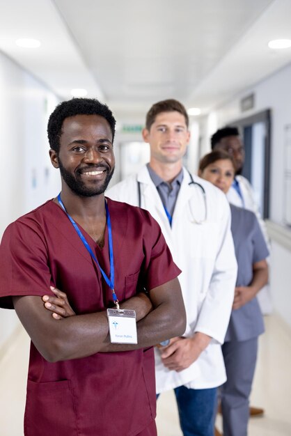 Portrait inaltéré d'un médecin afro-américain souriant et de divers collègues à l'hôpital