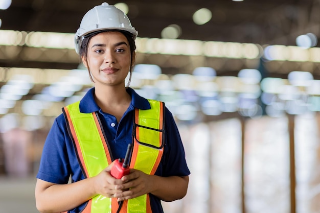 Portrait Indian woman worker superviseur avec combinaison de sécurité ingénieur travailler dans un grand entrepôt d'usine