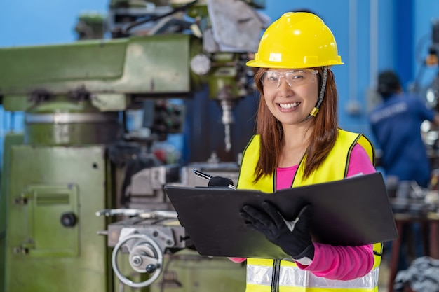 Portrait d'ingénieur commercial femme asiatique vérifiant la liste des tâches sur papier