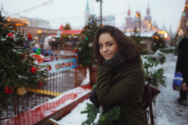 Portrait intérieur d'une belle fille en veste d'hiver rouge qui souffle de la neige sur la Foire de Noël Concept de vacances de Noël Espace de copie Place Rouge de Moscou