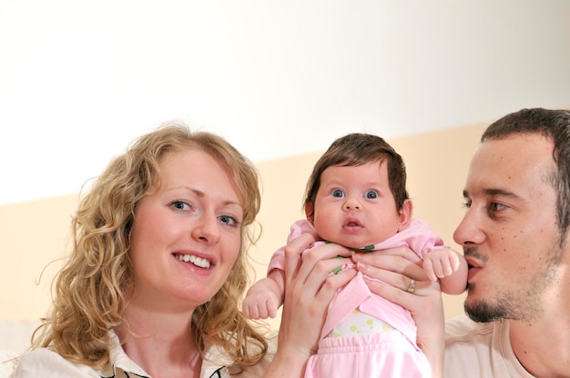 portrait intérieur avec une jeune famille heureuse et un mignon petit bébé