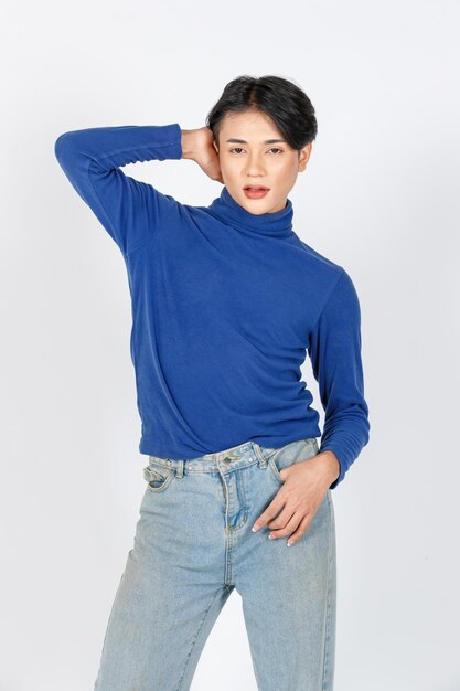 Portrait isolé découpe studio gros plan tir asiatique jeune sexy mince à la mode LGBTQ gay mannequin masculin en col roulé chemise à manches longues jeans debout posant regarder la caméra sur fond blanc