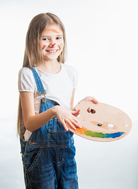 Portrait isolé d'une jolie fille d'artiste avec le visage en peinture