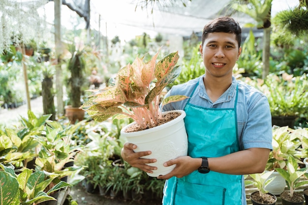 Portrait de jardinier tenant des plantes et des fleurs