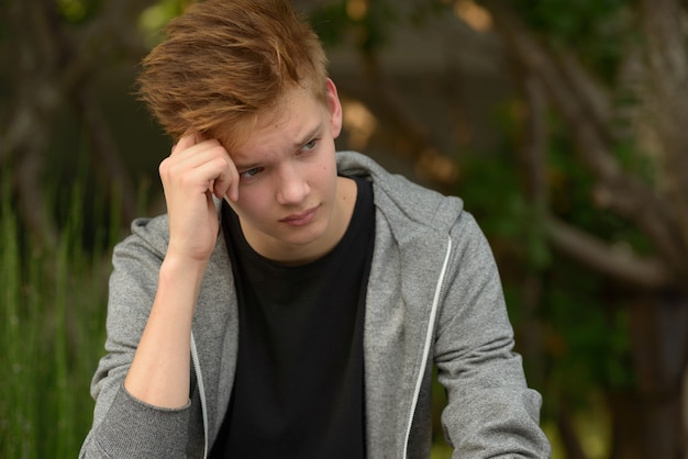 Portrait de jeune adolescent beau dans le parc en plein air