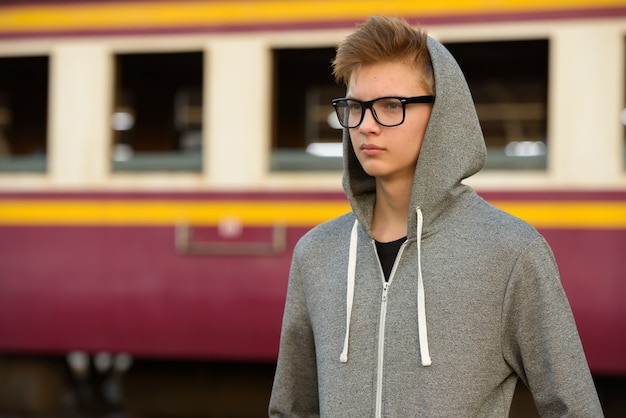 Portrait de jeune adolescent beau à la gare ferroviaire