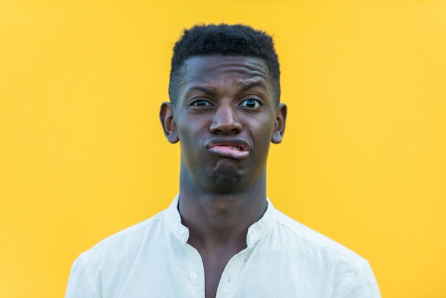 Photo portrait de jeune adolescent sur mur jaune