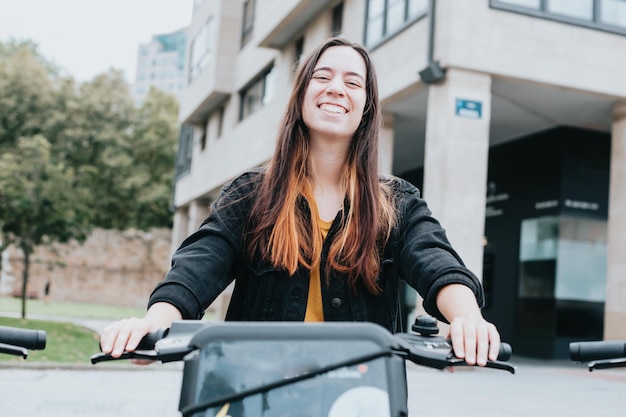 Portrait d'un jeune adulte louant un vélo électrique pour visiter la ville