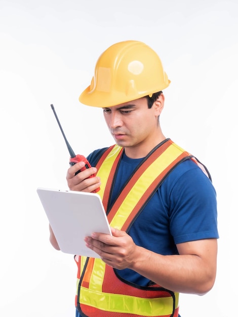 Portrait jeune architecte homme ingénierie avec casque jaune tenant mégaphone et tablette à la main Il debout bras croisés isolé sur fond blanc avec espace de copie