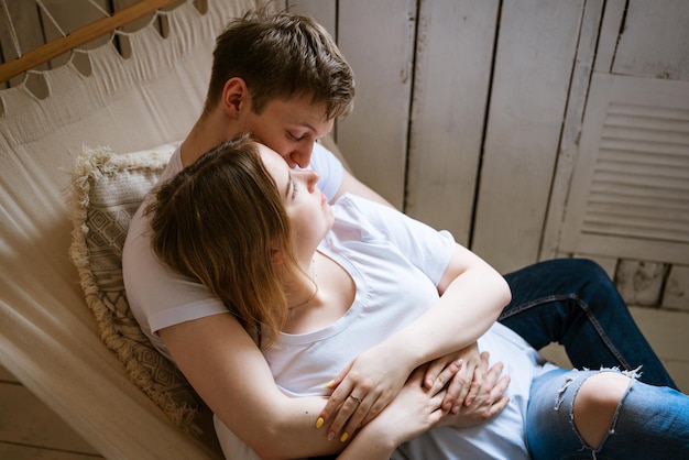 Portrait d'un jeune beau couple un jeune homme adulte et une femme dans un hamac la femme est un attr...